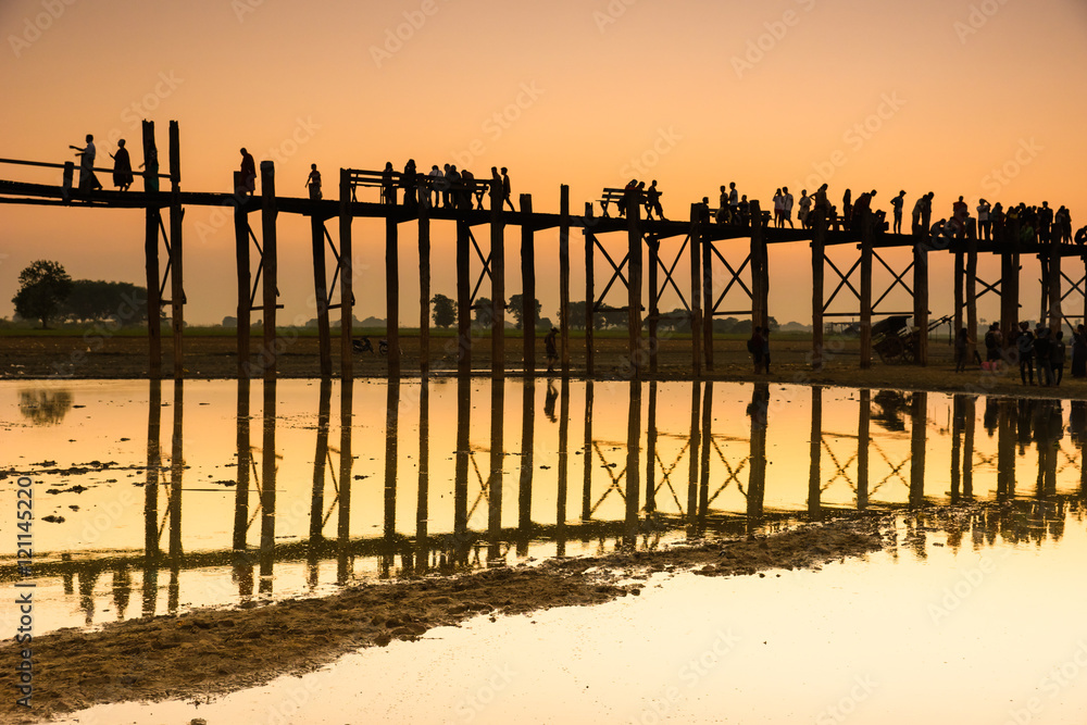 Sunset with silhouettes of people on Bridge U-Bein teak bridge i
