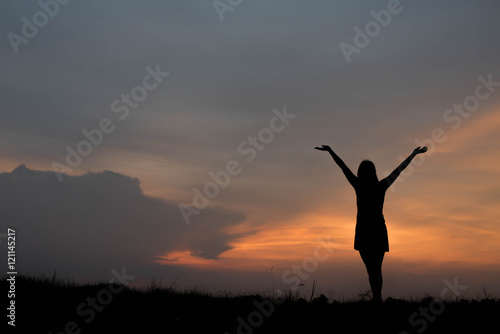 silhouette of woman enjoys outdoor at sunset