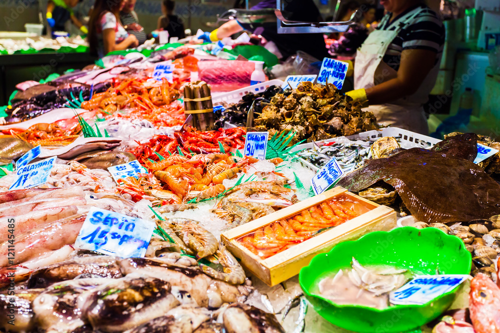 Countertop with various fresh seafood in Boqueria market. Barcelona. Calamari, shrimp, brine and various shells beautifully laid out on the ice on the counter.