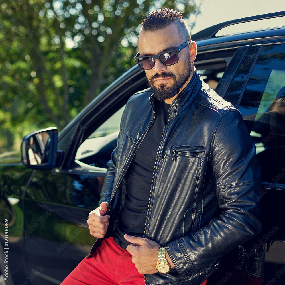 Stylish man posing near a car