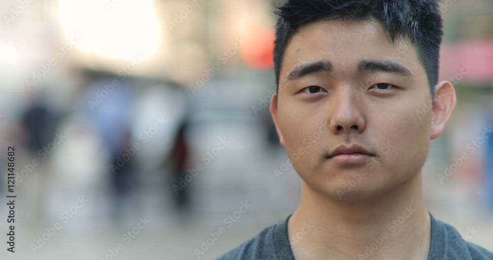 Young Asian man in city face portrait Young Asian man in city face portrait