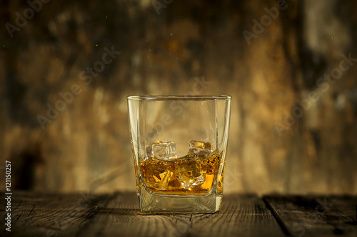Fototapeta Naklejka Na Ścianę i Meble -  Whiskey glass on wooden table and wooden background