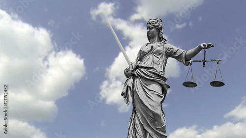 Statue of Lady Justice zooming out in front of moving clouds