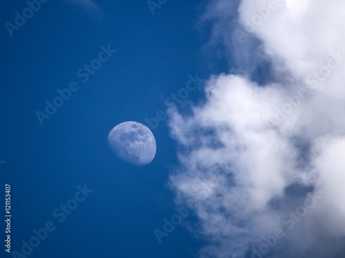 Moon with clouds on blue sky during daylight