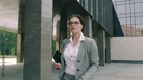 business woman running late for work and looking at the time