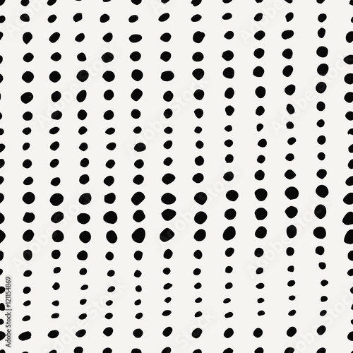 Seamless pattern with irregular dots in black on cream background.