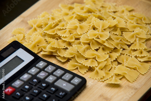 calulator with pasta on wooden background, calories photo