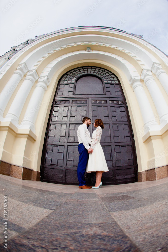The bride and groom standing next to the large iron gates