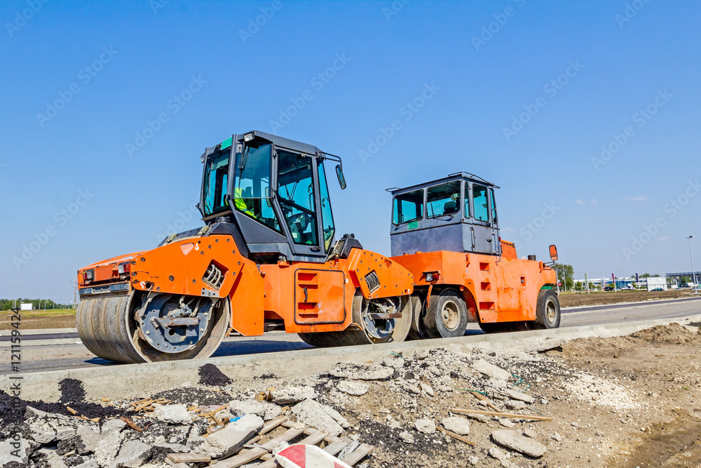 Steamrollers are parked at building site. Machinery for road con Steamrollers are parked at building site. Machinery for road con