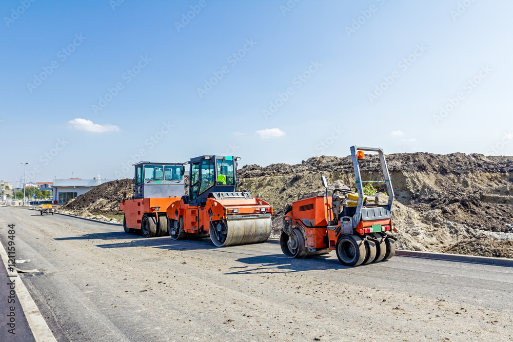 Steamrollers are parked at building site. Machinery for road con Steamrollers are parked at building site. Machinery for road con