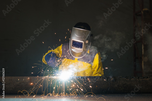 Fényképezés Industrial welder in manufacturing plant welding to finish a pipeline