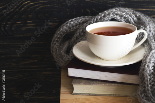 Fotografía Warm knitted plaid, cup of tea and books