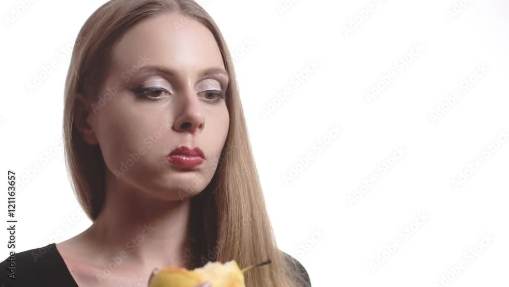 Beautiful young woman with red lips eating pear isolated on white background. Beautiful young woman with red lips eating pear isolated on white background.