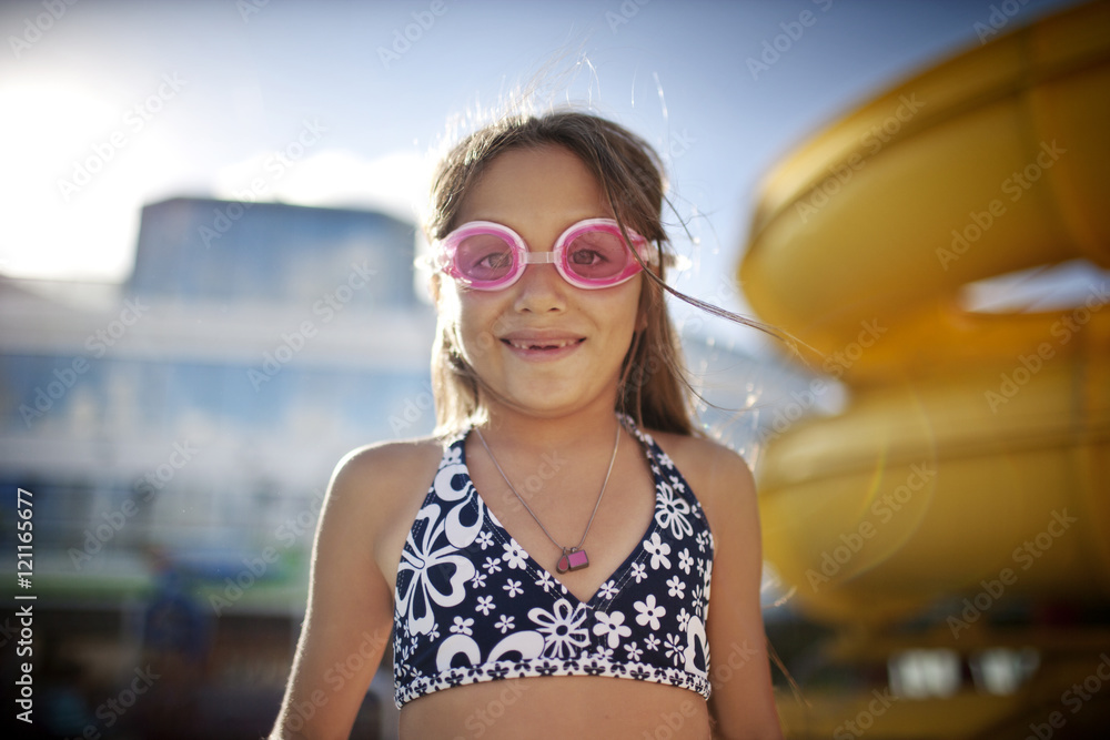 Young girl with missing teeth wearing swimming goggles at a swmming pool. Young girl with missing teeth wearing swimming goggles at a swmming pool.