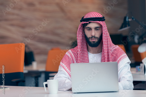 Arabian businessman working in modern startup office photo