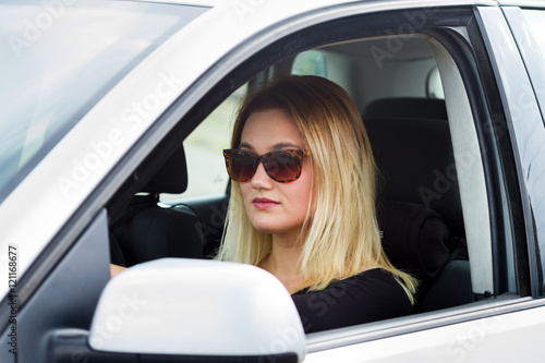 young blonde woman driver in her car