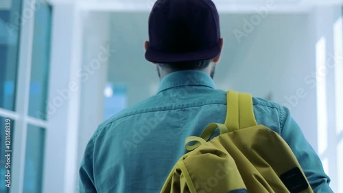 Back view of man going along hallway