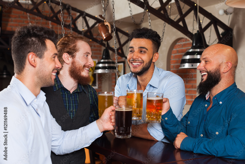 Man Group In Bar Clink Glasses Toasting, Drinking Beer Hold Mugs, Mix Race Cheerful Friends Wear Shirts Man Group In Bar Clink Glasses Toasting, Drinking Beer Hold Mugs, Mix Race Cheerful Friends Wear Shirts