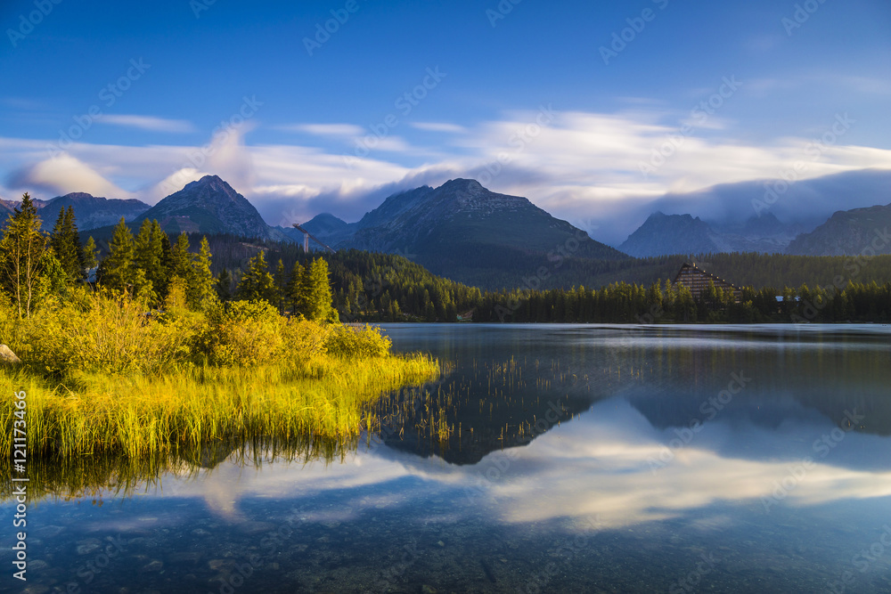 The sunrise over a lake in the park High Tatras. Strbske Pleso, Slovakia, Europe. The sunrise over a lake in the park High Tatras. Strbske Pleso, Slovakia, Europe.