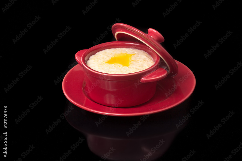 Oatmeal cooked with milk in a ceramic pot. Oatmeal cooked with milk in a ceramic pot.