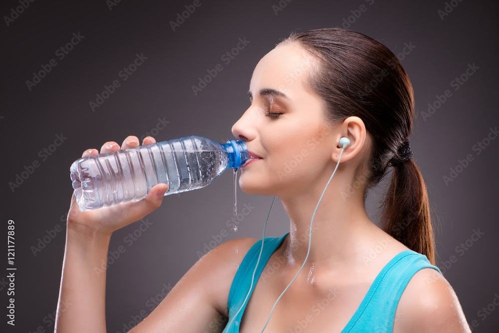 Woman doing sports with bottle of fresh water Woman doing sports with bottle of fresh water