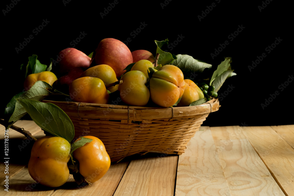 Fruits in basket on wood table