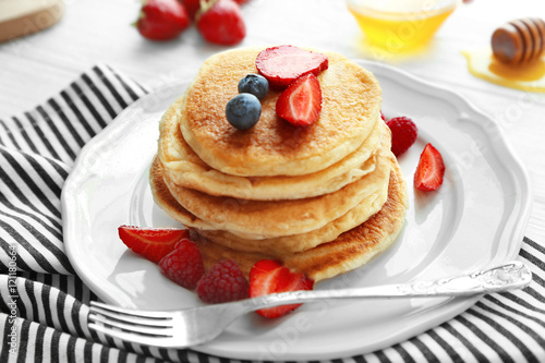 Tasty pancakes with fresh berries on plate