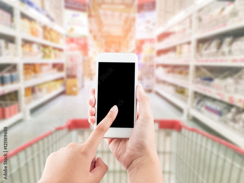 Female hand holding mobile smart phone on Supermarket blur backg Female hand holding mobile smart phone on Supermarket blur backg