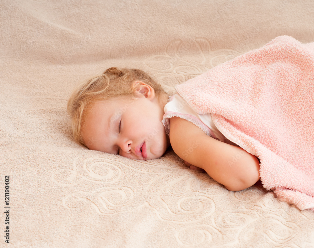 Beautiful sleeping child. Peaceful child lying on a bed in a bri Beautiful sleeping child. Peaceful child lying on a bed in a bri