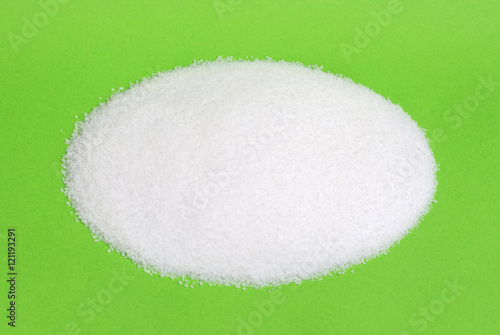 Pile of white sugar isolated on colored background