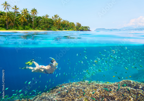 Woman snorkeling in clear tropical waters.