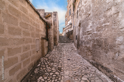 typical old street and stairs view of Matera under blue sky