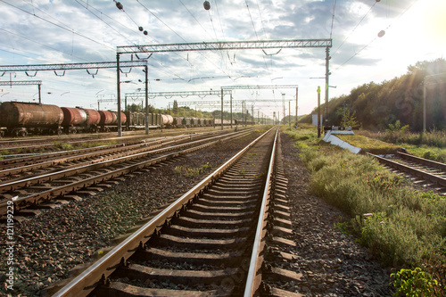 Railway with freight train under cloudy sky