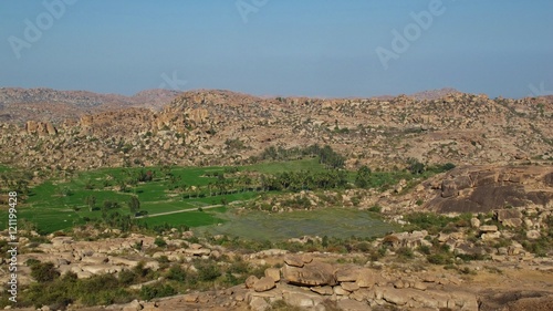 Rice fields in Hampi surrounded by granite mountains