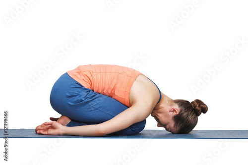 Beautiful sporty fit yogi girl practices yoga asana balasana
