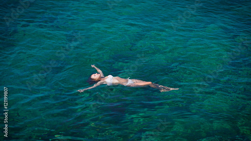 Young woman swimming in beautiful azure sea
