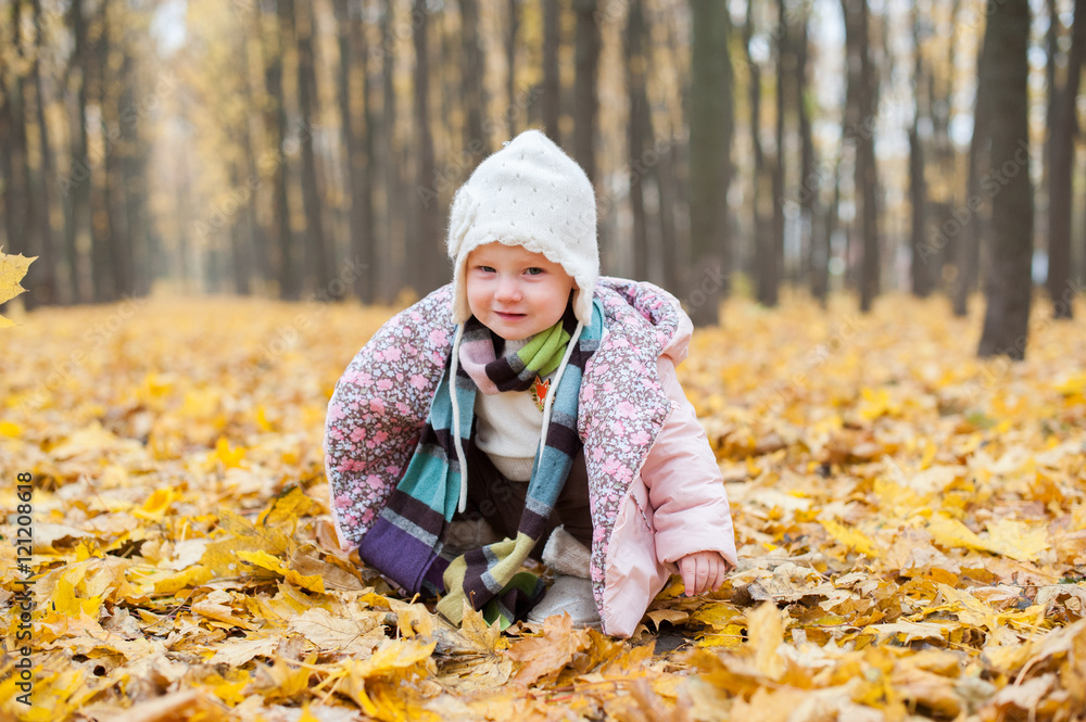 A child sitting in autumn leaves in doubt