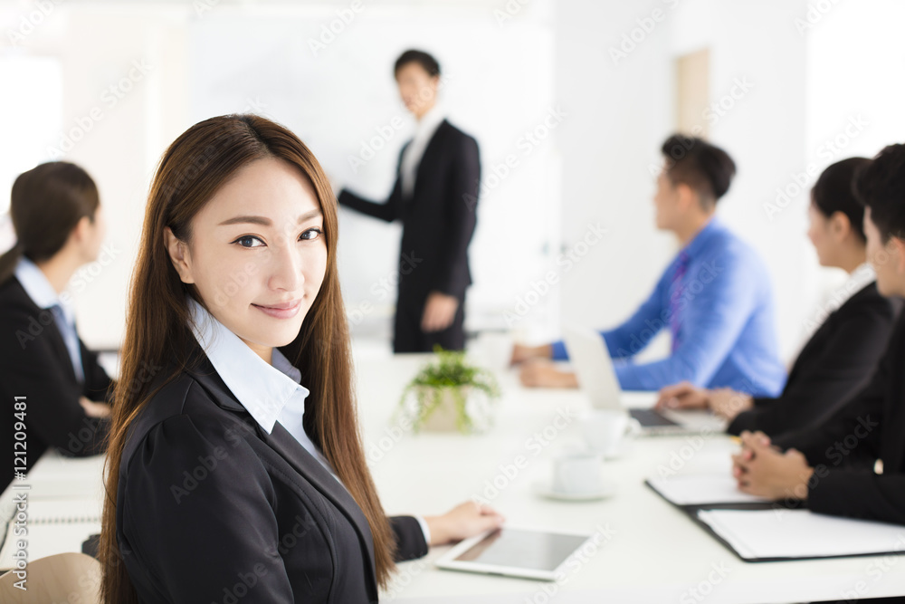 Smiling businesswoman looking at camera with colleague Smiling businesswoman looking at camera with colleague