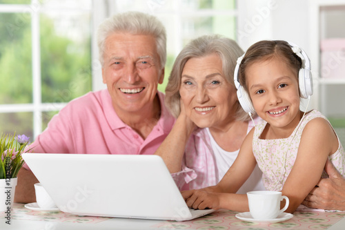grandparents and little girl using laptop