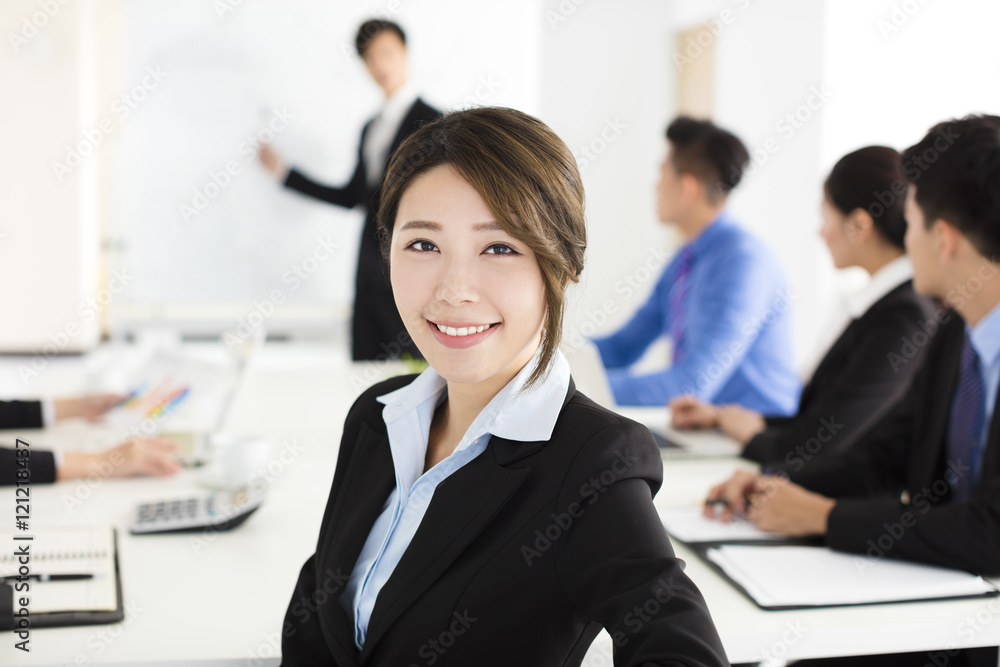 Smiling businesswoman looking at camera with colleague Smiling businesswoman looking at camera with colleague