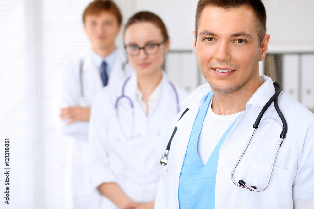 Cheerful smiling male doctor with medical staff at the hospital Cheerful smiling male doctor with medical staff at the hospital