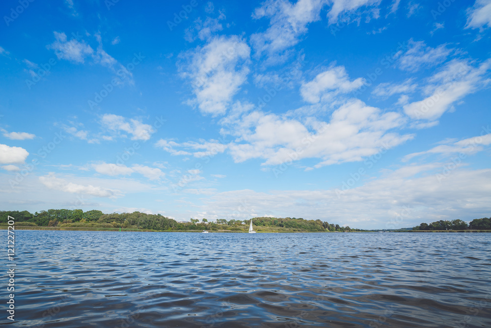 River landscape with a sailboat in the water