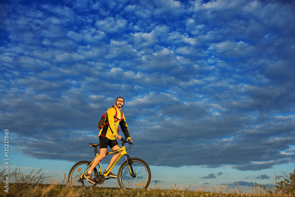 Obraz premium Young man cycling on a rural road