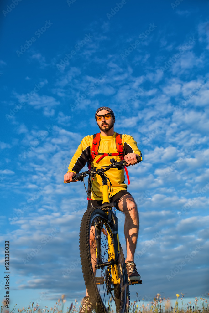 Fototapeta premium Young man cycling on a rural road