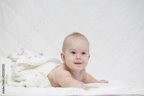 Adorable girl baby, wrapped in bath towel after bathing .