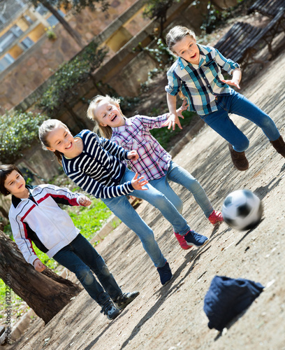 Group of children running after ball