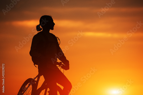 Silhouette of a bike on sky background during sunset