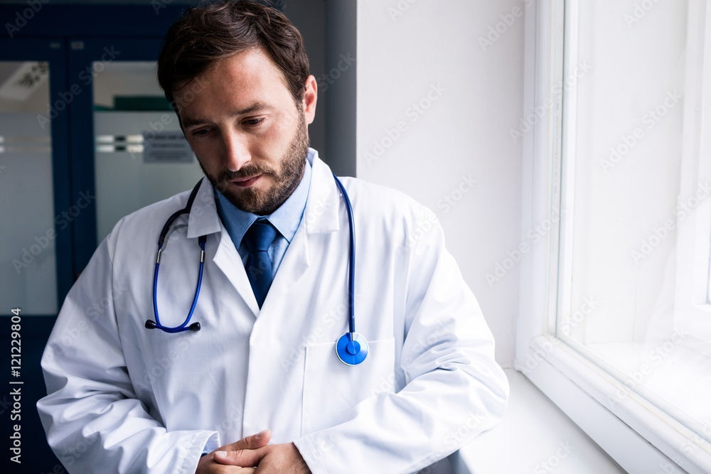 Sad doctor standing in corridor Sad doctor standing in corridor