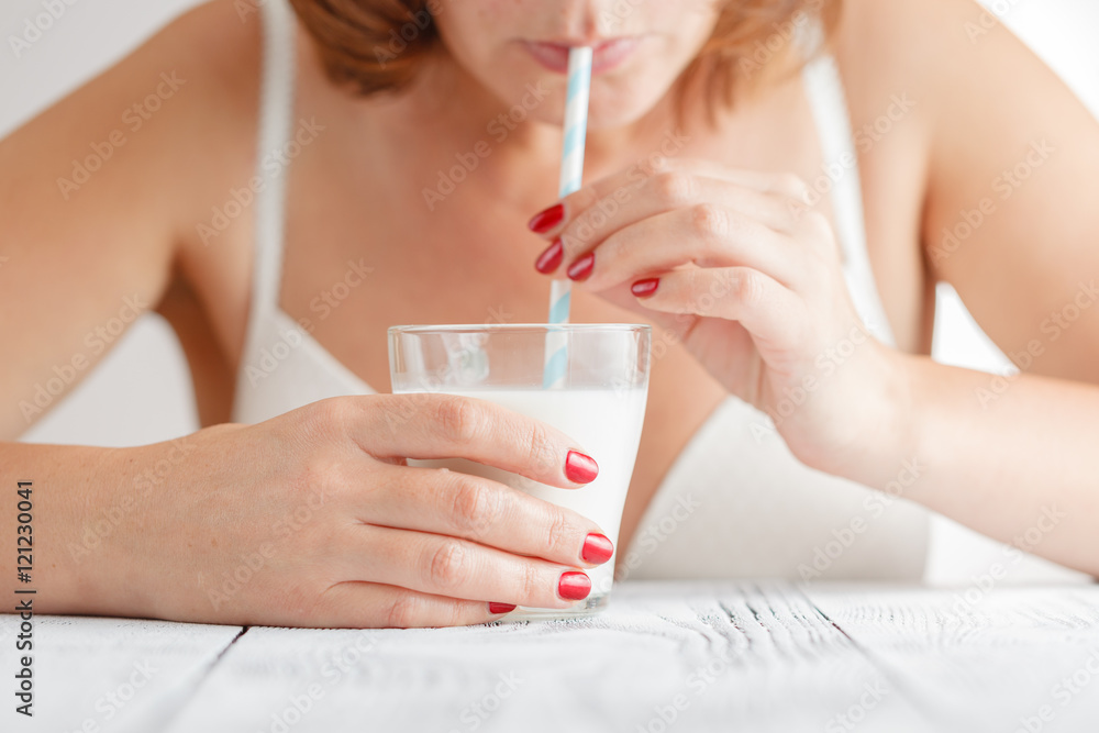 Woman drinks milk using drinking straw Woman drinks milk using drinking straw