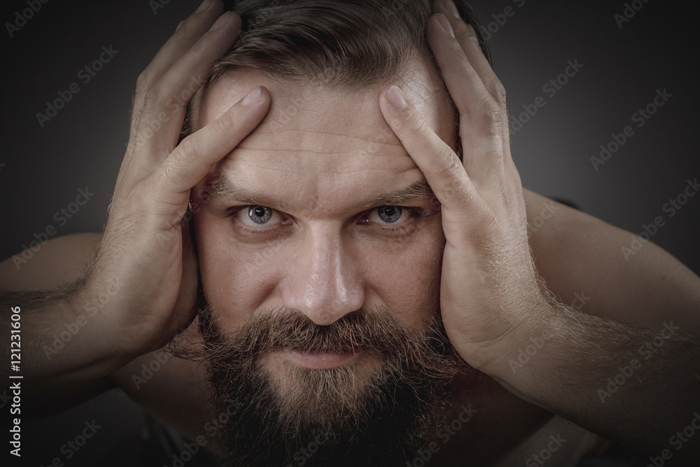 Handsome young man holding the head in his head Handsome young man holding the head in his head